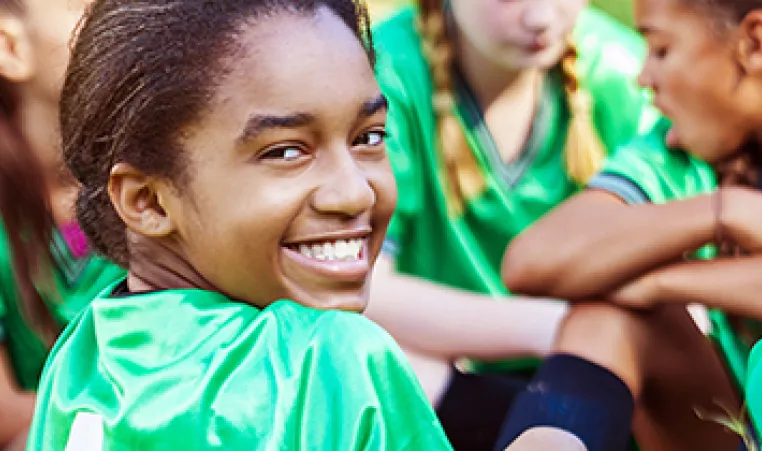 Girl smiling and playing soccer