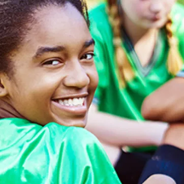 Girl smiling and playing soccer